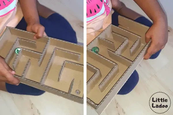 Child playing with marble maze game made with cardboard